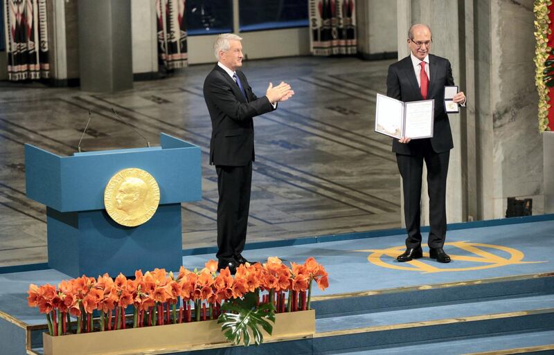 The Chairman of the Norwegian Nobel Committee Thorbjoern Jagland (L) applauds after awarding Ahmet Uzumcu (R), Director General of the Organisation for the Prohibiton of Chemical Weapons (OPCW), the 2013 Peace Nobel Prize at the Oslo City Hall on December 10, 2013. The Organisation for the Prohibiton of Chemical Weapons (OPCW) received the 2013 Peace Nobel Prize, attributed for its extensive efforts to eliminate chemical weapons.   AFP PHOTO / DANIEL SANNUM LAUTEN (Photo by DANIEL SANNUM LAUTEN / AFP)