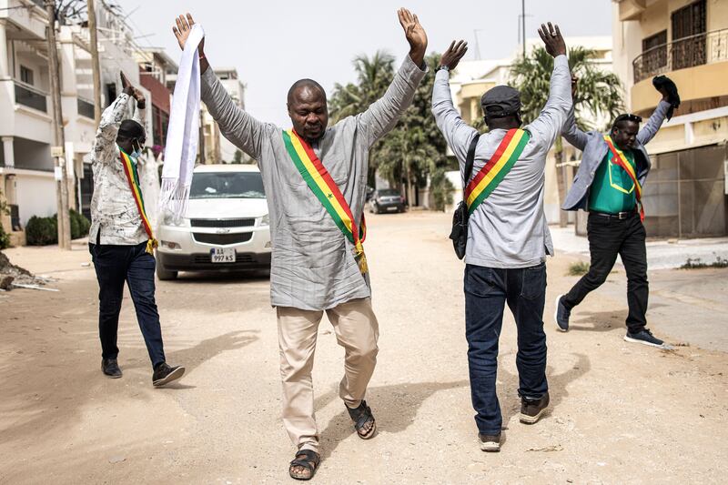 Senegalese opposition officials hold their hands up after tear gas was fired while they were trying to meet their leader, Ousmane Sonko, who is under house arrest in Dakar. AFP