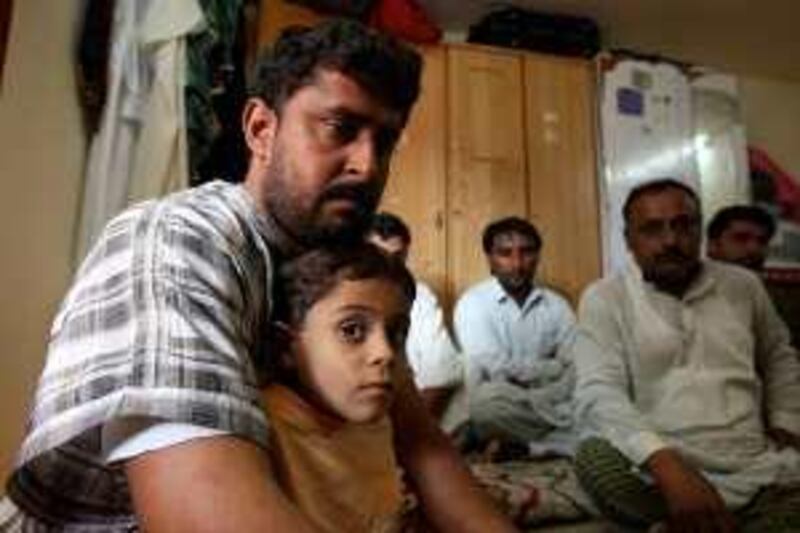 
DUBAI, UNITED ARAB EMIRATES Ð Dec 1: Mukhtiar Ahmed Khuda Baksh (left) with his seven years old son Mustaffa and some of the relatives at his home in Al Quasis in Dubai. (Pawan Singh / The National) For News. Story by Praveen Menon.
 *** Local Caption ***  PS0112- PAK FAMILY03.jpg