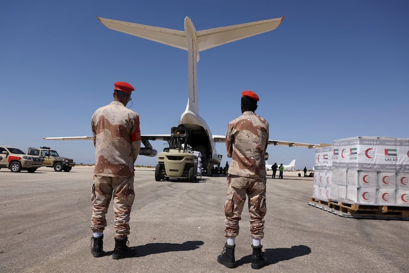Libyan military officers watch workers unload relief items arriving from the United Arab Emirates to provide aid following fatal floods in Derna and neighbouring areas, at Benina International Airport in Benghazi, Libya, September 15, 2023.  REUTERS / Amr Alfiky