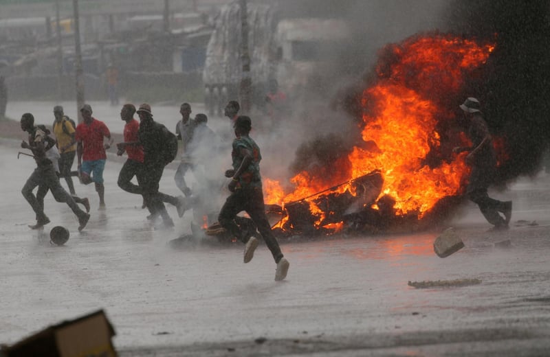 FILE PHOTO: People run at a protest as barricades burn during rainfall in Harare, Zimbabwe January 14, 2019. REUTERS/Philimon Bulawayo/File Photo