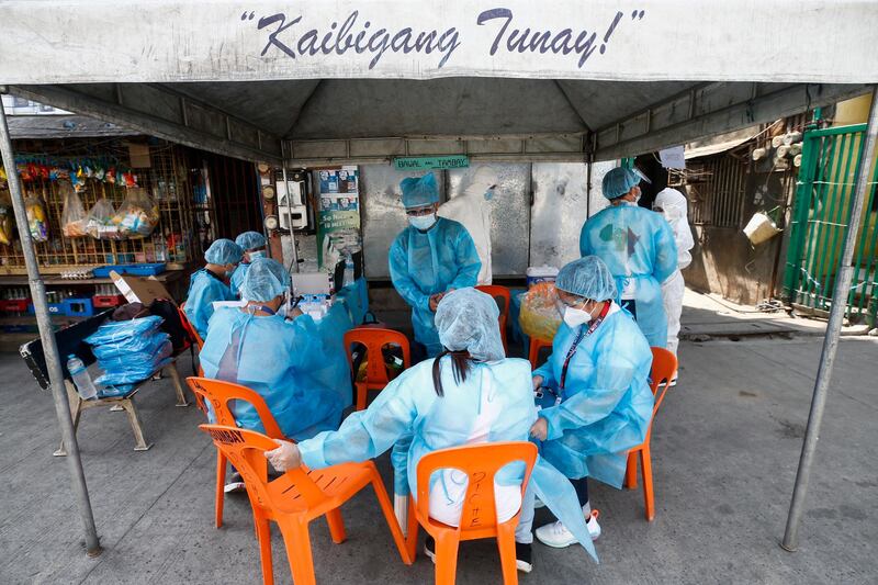 Health workers wearing protective suits prepare to carry out community Covid-19 testing in Manila, capital  of the Philippines. EPA