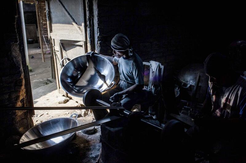 Tarno, a worker at Putra Logam workshop in Yogyakarta, Indonesia, is paid around 40,000 rupees a day or equivalent to $3.46 for polishing pans. Ulet Ifansasti / Getty Images