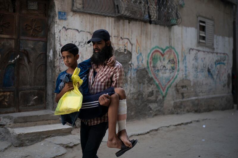 Raed Abu Khader, right, carries his 12-year-old son Mohammed as they return from the hospital in Gaza City. Mohammed was shot in the leg at one of the demonstrations on Gaza strip's border with Israel. Ever since Hamas launched demonstrations in March against Israel's blockade of Gaza, children have been a constant presence in the crowds. Since then, U.N. figures show that 948 children under 18 have been shot by Israeli forces and 2,295 have been hospitalized, including 17 who have had a limb amputated.  AP