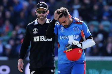 New Zealand's Kane Williamson, left checks on Afghanistan's Rashid Khan after a ball bowled by Lockie Ferguson bounced off Rashid's helmet and onto the stumps. AP Photo