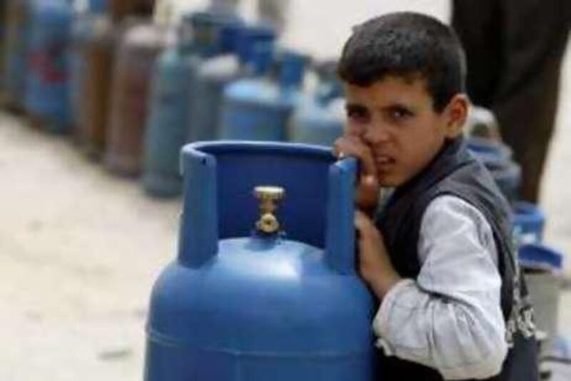 A Palestinian boy waits to fill cooking gas canisters at a gas station in Gaza May 13, 2008. Israel resumed fuel shipments to Gaza's main power station on Monday, a senior generating plant official said. REUTERS/Ismail Zaydah (GAZA) *** Local Caption ***  JER08_PALESTINIANS-_0513_11.JPG