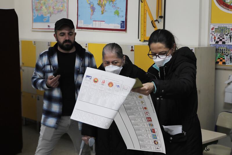 Voters take a closer look at the candidates on the ballot, in Ankara. Getty