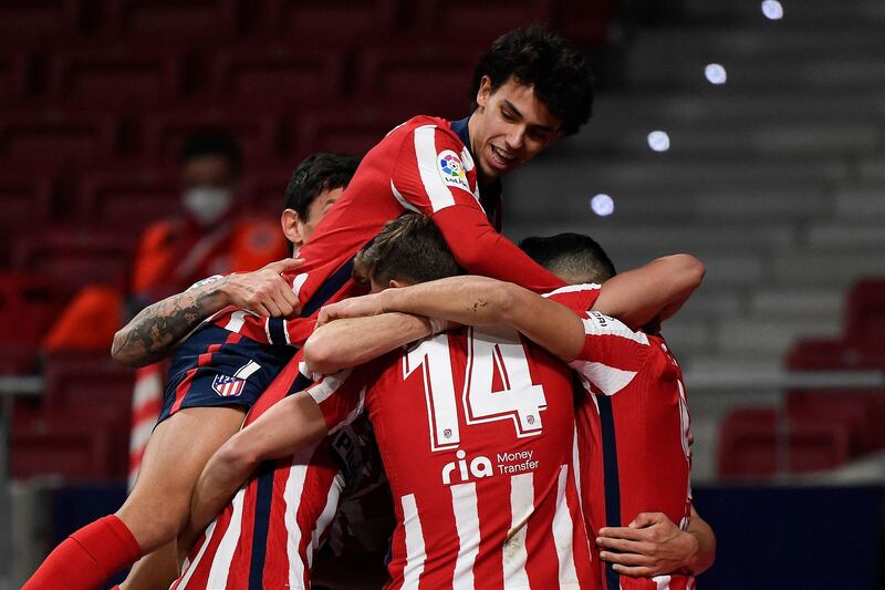Atletico's Joao Felix, top, jumps on teammates after Luis Suarez scored from the spot in their 2-1 win over Bilbao. AFP