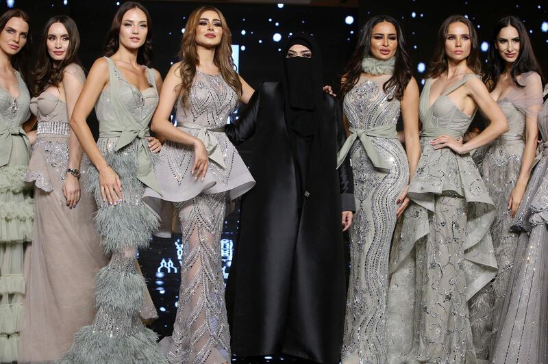 Kuwaiti designer Wasmiya al-Harbi (centre) poses with models wearing her creations during the "Sehr al-Sharq "or "The Magic of the Orient" fashion show, in Kuwait City.   AFP