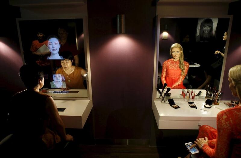 A woman looks at a mirror next to the wax figure of Paris Hilton at Grevin Wax Museum in Seoul, South Korea, July 30, 2015. The French-based Musee Grevin has opened its first Asian outpost in central Seoul with about 80 wax figures, including Korean cultural and sports figures. Kim Hong-Ji / Retuers