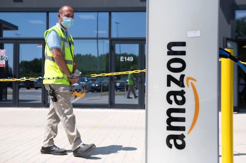 TORRAZZA PIEMONTE, ITALY - JUNE 03: Man walks near of Amazon logo in Amazon Headquarter on June 03, 2021 in Torrazza Piemonte near Turin, Italy. Amazon Italy rolls out an on-site vaccine site for its employees. as Italy steps up next wave of vaccine campaigns. (Photo by Stefano Guidi/Getty Images)