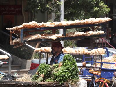 An Egyptian man carries a rack full of bread in the Abdeen district of Cairo. EPA