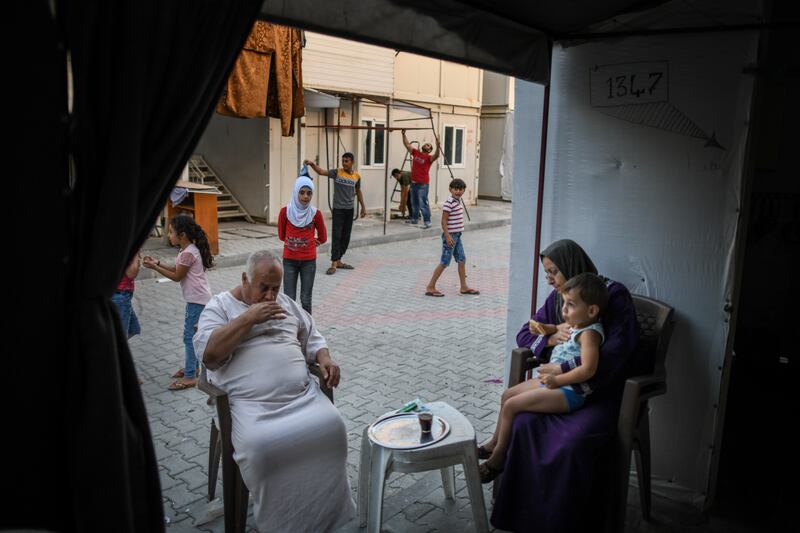 A Syrian family sits in front of their home in the camp. Getty Images