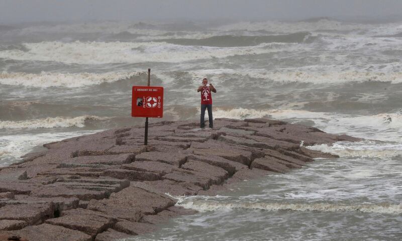 Michael Scott uses his smartphone to livestream the rain and storm surge of Hurricane Harvey from the 59th Street rock groin in Galveston, Texa. Jennifer Reynolds / The Galveston County Daily News via AP