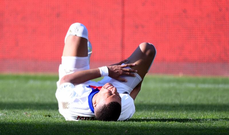 Paris Saint-Germain's French forward Kylian Mbappe reacts in pain during the match against Metz. AFP
