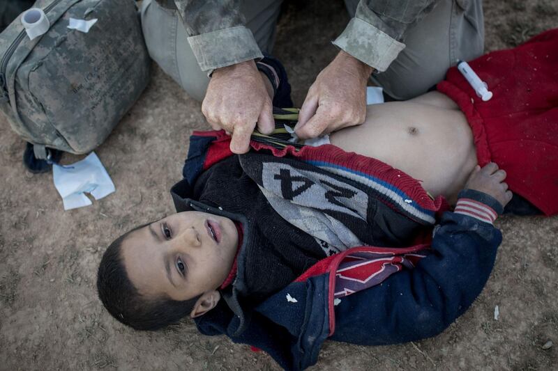 A young boy receives medical treatment for a gunshot wound by a member of the Free Burma Rangers medical unit after arriving at an SDF position on the outskirts of Bagouz. Getty Images