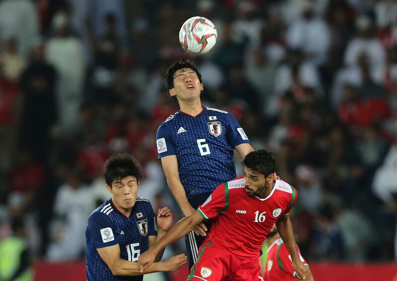 Japan's Water Endo, center, heads the ball against Oman's Muhsen Al Ghassani. AP Photo