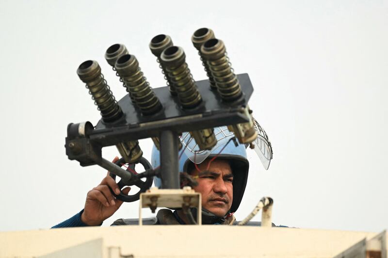 A Rapid Action Force personnel stands atop an armoured vehicle at a road block in Ghazipur. AFP