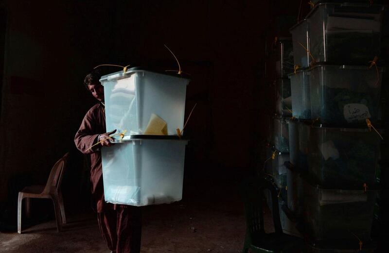 An Afghan election commission worker carries a ballot box at a vote counting centre in Jalalabad on April 6. A roadside bomb hit a truck carrying full ballot boxes in northern Afghanistan, killing three people a day after the country voted for a successor to President Hamid Karzai. Eight boxes of votes were destroyed in the blast, which came as the three leading candidates voiced concerns about possible fraud. Noorullah Shirzada / AFP Photo

