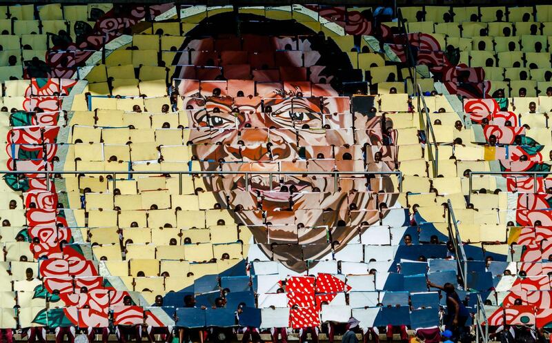 People display the portrait of Zimbabwe's president Emmerson Mnangagwa during Independence Day celebrations at the National Sports Stadium in Harare.  Jekesai Njikizana / AFP Photo
