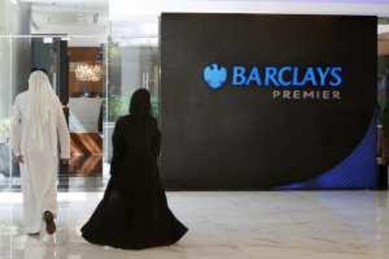A couple walks past a Barclays logo in a Barclays Bank in Dubai November 5, 2008. Sheikh Mansour Bin Zayed Al Nahyan, a member of Abu Dhabi's royal family, is to invest up to 3.5 billion pounds ($5.6 billion) in Barclays Plc, giving him a stake of up to 16.3 percent in Britain's second-biggest bank.  REUTERS/Ahmed Jadallah (UNITED ARAB EMIRATES) *** Local Caption ***  DUB07_BRITAIN-BARCL_1105_11.JPG