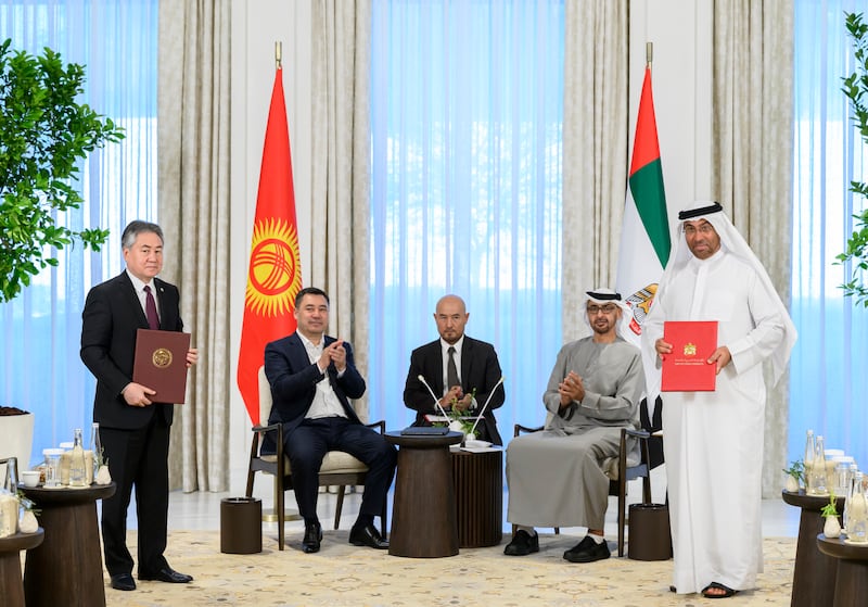 Ahmed Al Sayegh, UAE Minister of State, and Zheenbek Kulubaev, Minister of Foreign Affairs of Kyrgyzstan, exchange agreements.