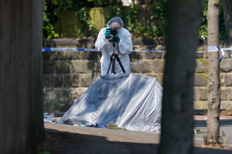 A police forensics officer at the scene on the city's Magdala Road. PA