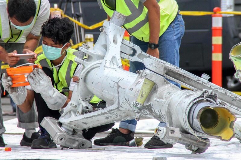 Lion Air investigators examine part of the landing gear of the ill-fated Lion Air flight JT 610 at the port in northern Jakarta on November 5, 2018. The Boeing 737 Max 8 with 189 people plunged into the Java Sea just 12 minutes after takeoff on a routine one-hour flight from Jakarta to Pangkal Pinang city in Sumatra on October 29. / AFP / AZWAR IPANK
