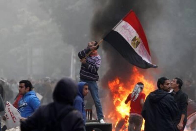 An Egyptian protester waves his national flag as demonstrators gather outside the parliament building during clashes with soldiers near Cairo's Tahrir Square on December 16, 2011. Egyptian troops clashed with petrol bomb-throwing protesters against military rule in Cairo, as the worst violence in weeks overshadowed the count in the second phase of a landmark general election. AFP PHOTO/MOHAMMED ABED

 *** Local Caption ***  487757-01-08.jpg