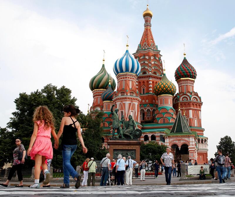 MOSCOW, RUSSIA - AUGUST 06:  Tourists explore Red Square in front of St. Basil's Cathedral ahead of the 14th IAAF World Athletics Championships on August 6, 2013 in Moscow, Russia.  (Photo by Jamie Squire/Getty Images)