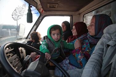 Syrians sit in a vehicle as they drive towards the northern areas of Syria's Idlib province near the Syrian-Turkish border as they flee the bombardments in the southern areas of the country's last major opposition bastion, on December 20, 2019. / AFP / Aaref WATAD