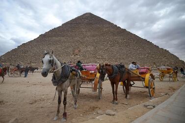 Tourist horse-drawn carts waiting by the base of the Great Pyramid at the Giza province, south of Egypt's capital Cairo. AFP