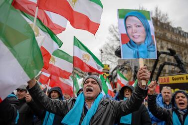 People wave former Iranian flags and a picture of Maryam Rajavi, leader of the People's Mujahedin of Iran. AFP