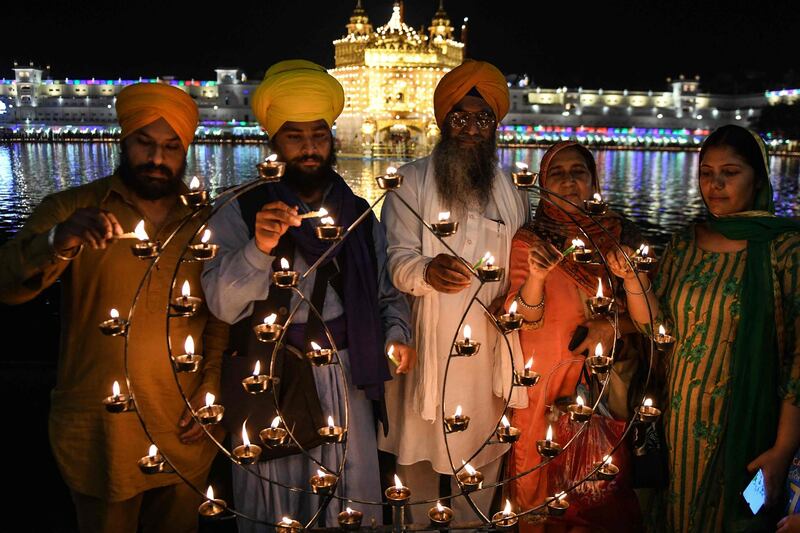 Sikh devotees light candles on the occasion of the Baisakhi festival at the Golden Temple, Amritsar. AFP
