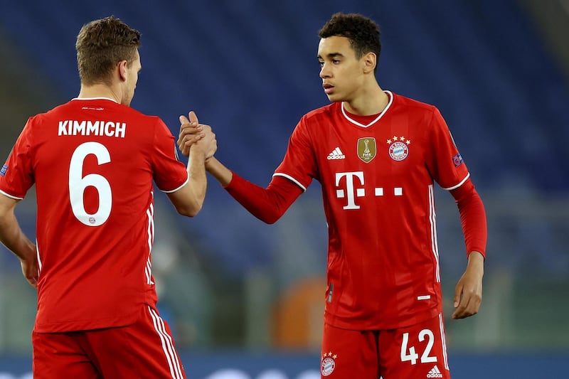 ROME, ITALY - FEBRUARY 23: Jamal Musiala (R) of FC Bayern MÃ¼nchen reacts with his team mate Joshua Kimmich during the UEFA Champions League Round of 16 match between Lazio Roma and Bayern MÃ¼nchen at Olimpico Stadium on February 23, 2021 in Rome, Italy. (Photo by Alexander Hassenstein/Getty Images)