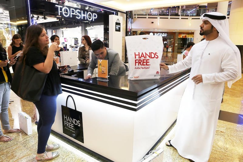 Hussain Moosa , director of Mall of the Emirates, informs a customer about the mall’s hands free shopping service.  Pawan Singh / The National