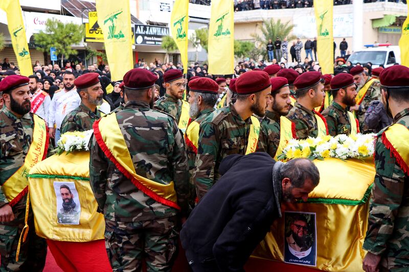 Hezbollah fighters carry the coffins of a fellow fighter and of one of his relatives who were killed in Israeli bombardment, in Bint Jbeil, in the south of Lebanon, on December 27.  AFP