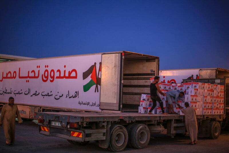 Palestinians unload boxes of Egyptian aid to distribute among residents of the Gaza Strip. EPA