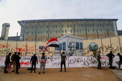 Supporters of Iraq's Popular Mobilisation Forces prepare to burn a large printed image of the US  Embassy, to mark the anniversary of the killing of Iranian Quds Force general Qassem Soleimani. Reuters