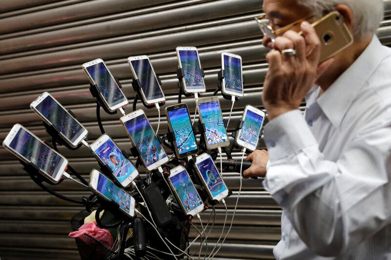 Taiwanese Chen San-yuan, 70, known as 'Pokemon grandpa', talks on his phone as he plays the game 'Pokemon Go' by Nintendo in New Taipei City, Taiwan. Reuters