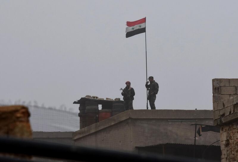Syrian national flag flying over a building as regime forces gather in the southern countryside of the northern Kurdish-controlled city of Manbij.  The unexpected US pullout announcement left Syria's Kurds scrambling to find a new ally in the Damascus regime, as they feared losing US support would leave them exposed to a long-threatened Turkish assault.  AFP