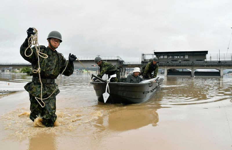 Japan Ground Self-Defense Force members use a boat to evacuate a resident from a flooded area caused by heavy rains in Kurashiki, Okayama prefecture, southwestern Japan. Koki Sengoku/AP Photo