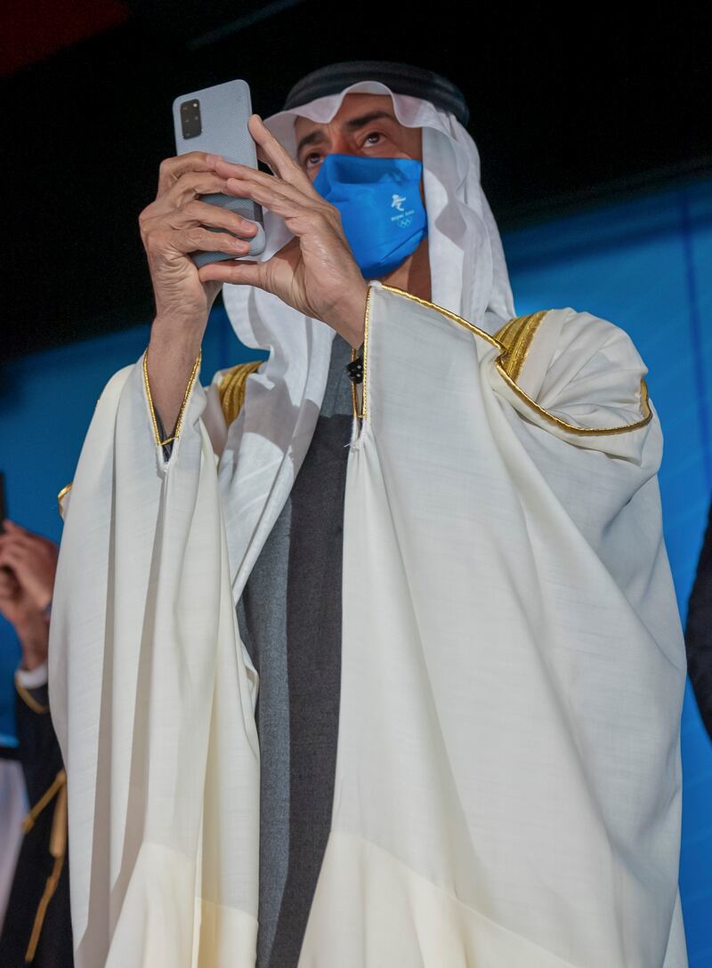 Sheikh Mohamed takes a photograph during the opening ceremony of the 2022 Beijing Winter Olympics.