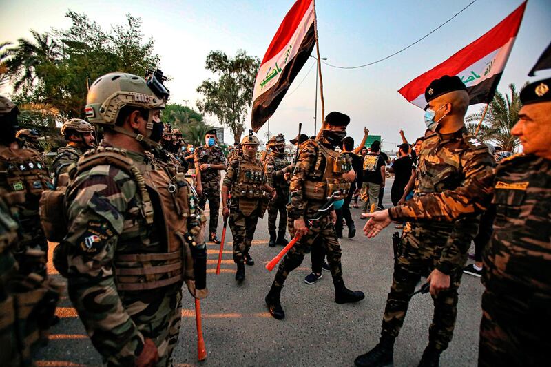 Iraqi security forces prevent protesters from breaking into the provincial council building during a protest demanding free elections in Basra, Iraq, Tuesday, Sept. 15, 2020. (AP Photo/Nabil al-Jurani)