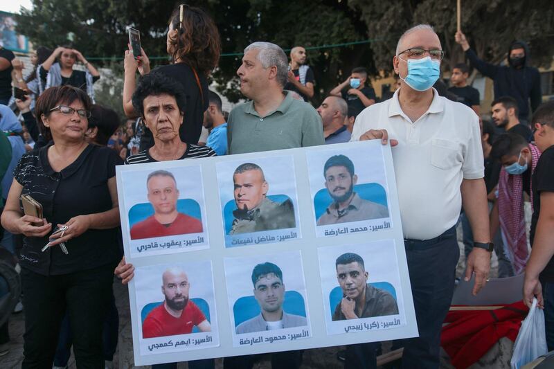 Protesters in the northern Israeli city of Nazareth carry a placard in support of six Palestinian prisoners who escaped from Israel's Gilboa jail. AFP