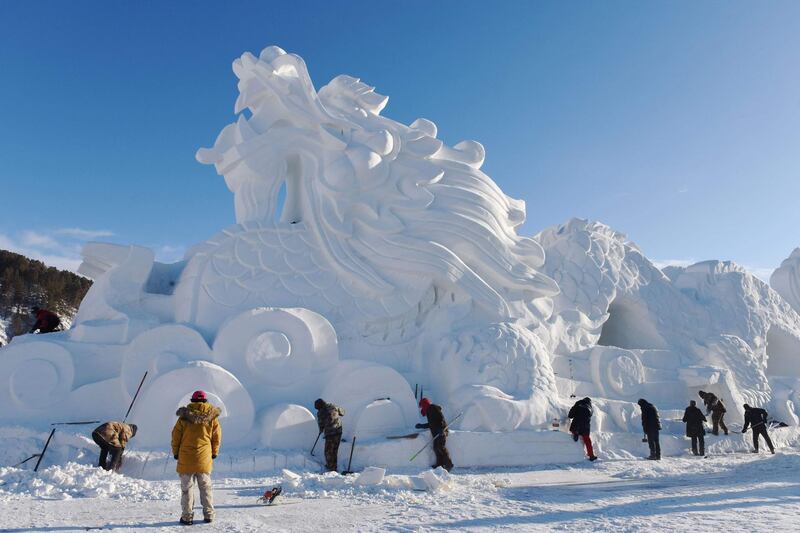Workers carving a dragon sculpture from snow and ice in preparation for the winter tourism season in Mohe in China's northeast Heilongjiang province. AFP