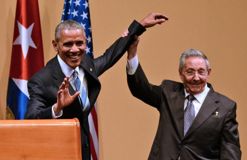 Cuban President Raul Castro (R) raises US President Barack Obama's hand during a joint press conference at the Revolution Palace in Havana on March 21, 2016. Cuba's Communist President Raul Castro on Monday stood next to Barack Obama and hailed his opposition to a long-standing economic "blockade," but said it would need to end before ties are fully normalized.   AFP PHOTO/STR (Photo by STR / AFP)