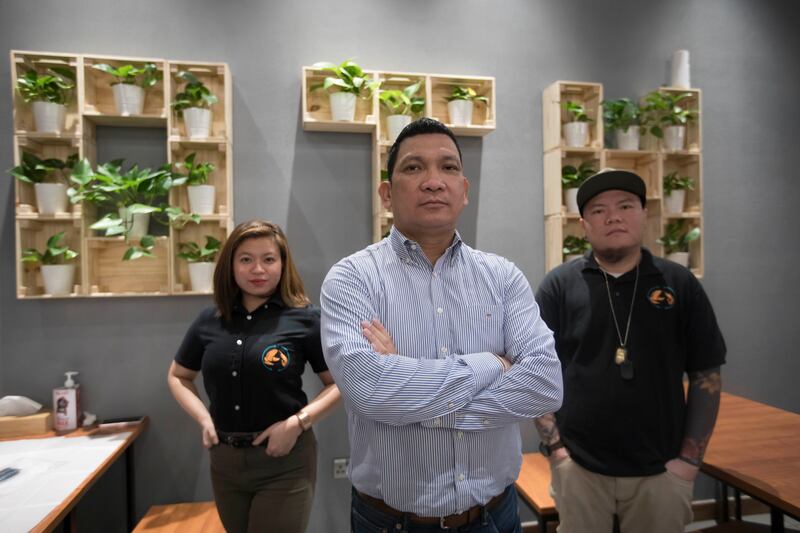 Rolly Brucales, centre, owner of the Off the Hook chain of restaurants in the UAE, provides financial literacy mentoring to 90 employees to help them better manage their earnings. Ruel Pableo for The National