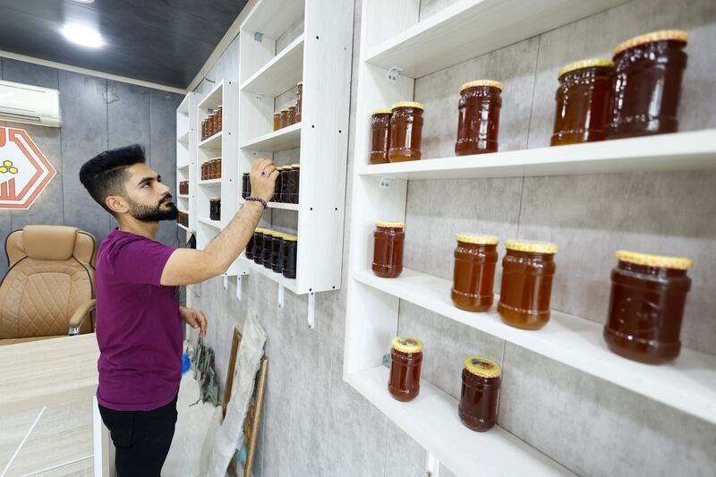 A beekeeper sells honey at a market in Najaf. Reduced yields are affecting farmers' livelihoods