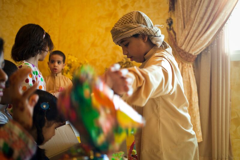 Sharjah, United Arab Emirates - June 23 2013 - Mohammad Al Jabri,12, packs little bags filled with sweets and crisps with his cousins at their home in the Leyyah district of the city. They are preparing for Hag El Leila, an Emirati tradition that occurs every year 15 days before the start of the month of Ramadan. The tradition involves children walking from door-to-door singing and collecting sweets and money. (Razan Alzayani / The National)  FOR RYM GHAZAL STORY  *** Local Caption ***  RA0623_hag_el_layla_003.jpg